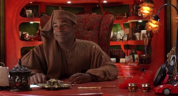 Movie still from “The Santa Clause 2” (2002), directed by Michael Lembeck – A man sitting at a table with a plate in front of him; Medium shot, Low angle