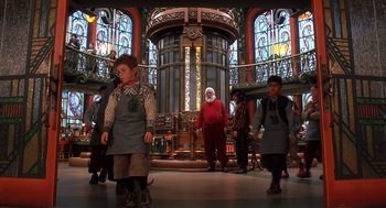Movie still from “The Santa Clause 2” (2002), directed by Michael Lembeck – A group of people standing in front of stained glass windows; Wide shot, Low angle
