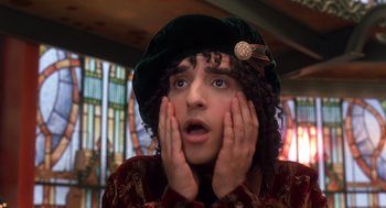 Movie still from “The Santa Clause 2” (2002), directed by Michael Lembeck – A young man with curly black hair wearing a green hat; Close Up shot, Low angle