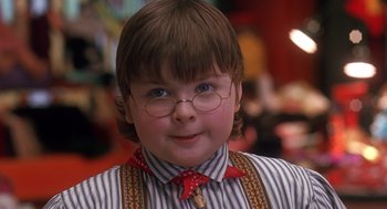 Movie still from “The Santa Clause 2” (2002), directed by Michael Lembeck – A young boy wearing glasses and a bow tie; Close Up shot, Over the shoulder angle