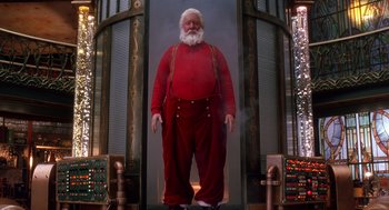 Movie still from “The Santa Clause 2” (2002), directed by Michael Lembeck – A man dressed as santa claus standing in front of a fire hydrant; Wide shot, Low angle