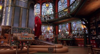 Movie still from “The Santa Clause 2” (2002), directed by Michael Lembeck – A man dressed as santa claus stands on a platform in front of stained - glass windows; Wide shot, Low angle