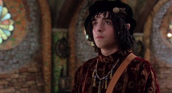 Movie still from “The Santa Clause 2” (2002), directed by Michael Lembeck – A young man in a hat and a long necklace; Medium shot, Over the shoulder angle