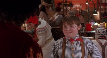 Movie still from “The Santa Clause 2” (2002), directed by Michael Lembeck – A young boy wearing glasses and a bow tie; Medium shot, Over the shoulder angle