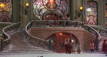 Movie still from “The Santa Clause 2” (2002), directed by Michael Lembeck – A group of people standing in front of an ornate staircase; Extreme Wide shot, High angle