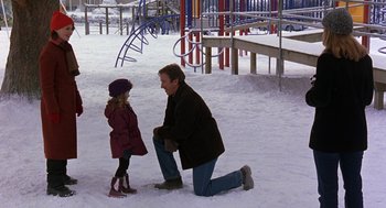 Movie still from “The Santa Clause 2” (2002), directed by Michael Lembeck – A man kneeling down next to a little girl in the snow; Wide shot, Over the shoulder angle