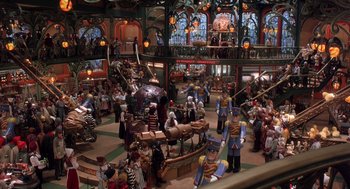Movie still from “The Santa Clause 2” (2002), directed by Michael Lembeck – A group of people standing in a room with a lot of toys; Extreme Wide shot, High angle