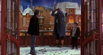 Movie still from “The Santa Clause 2” (2002), directed by Michael Lembeck – Two men and a boy standing in front of a building; Wide shot, Low angle