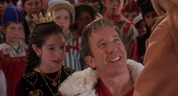 Movie still from “The Santa Clause 2” (2002), directed by Michael Lembeck – A man and a little girl in front of a group of people; Close Up shot, Over the shoulder angle