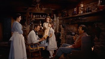 Movie still from “The Searchers” (1956), directed by John Ford – A man and a woman sitting in front of a girl and a boy; Wide shot, Low angle