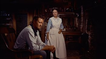 Movie still from “The Searchers” (1956), directed by John Ford – A man and a woman standing next to each other in a room; Medium shot, Low angle