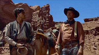 Movie still from “The Searchers” (1956), directed by John Ford – A man and a boy standing next to each other; Medium shot, Low angle