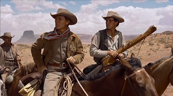 Movie still from “The Searchers” (1956), directed by John Ford – Two men on horses in the desert; Medium shot, Low angle