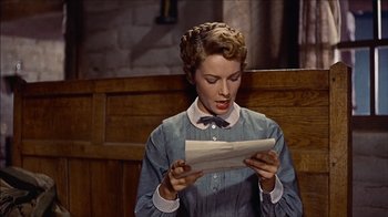 Movie still from “The Searchers” (1956), directed by John Ford – A young woman reading a paper in a room; Close Up shot, Low angle