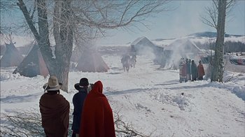 Movie still from “The Searchers” (1956), directed by John Ford – A group of people standing in the snow near tents; Extreme Wide shot, High angle
