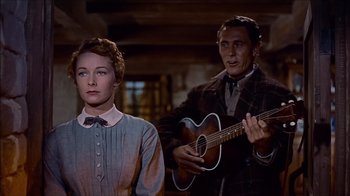 Movie still from “The Searchers” (1956), directed by John Ford – A man and a woman are playing a guitar; Medium shot, Low angle
