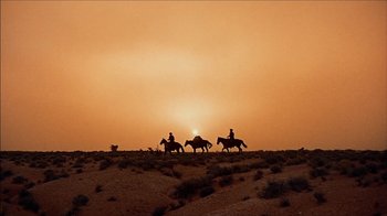 Movie still from “The Searchers” (1956), directed by John Ford – A group of people riding horses on a field; Extreme Wide shot, Low angle