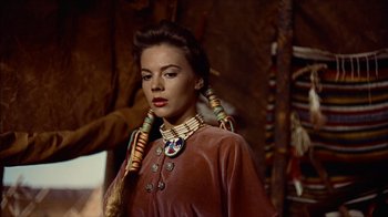 Movie still from “The Searchers” (1956), directed by John Ford – A woman in native american garb standing in front of a wall; Close Up shot, Over the shoulder angle