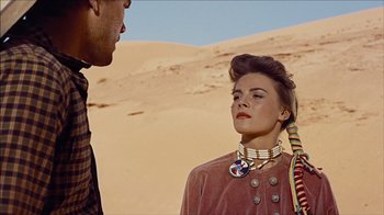 Movie still from “The Searchers” (1956), directed by John Ford – A man and a woman standing next to each other in the desert; Close Up shot, Over the shoulder angle