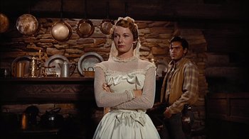 Movie still from “The Searchers” (1956), directed by John Ford – A man and a woman standing next to each other in a kitchen; Medium shot, Low angle
