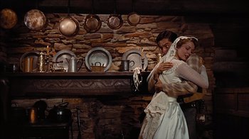 Movie still from “The Searchers” (1956), directed by John Ford – A man and a woman dressed in medieval garb in front of a fireplace; Medium shot, Low angle