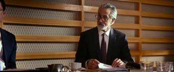 Movie still from “The Second Best Exotic Marigold Hotel” (2015), directed by John Madden – An older man sitting at a table with papers; Close Up shot, Over the shoulder angle