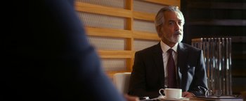 Movie still from “The Second Best Exotic Marigold Hotel” (2015), directed by John Madden – An older man sitting at a table with a cup of coffee in front of him; Close Up shot, Over the shoulder angle