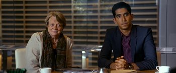 Movie still from “The Second Best Exotic Marigold Hotel” (2015), directed by John Madden – A man and a woman sitting in front of a table; Medium shot, Over the shoulder angle
