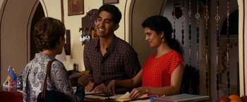 Movie still from “The Second Best Exotic Marigold Hotel” (2015), directed by John Madden – A man and a woman sitting at a table with papers; Medium shot, Over the shoulder angle