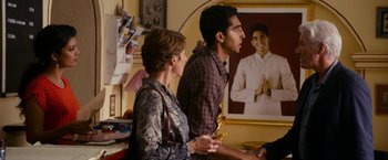 Movie still from “The Second Best Exotic Marigold Hotel” (2015), directed by John Madden – A man and a woman are playing a video game together; Medium shot, Over the shoulder angle