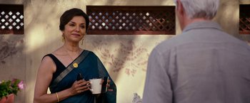 Movie still from “The Second Best Exotic Marigold Hotel” (2015), directed by John Madden – A woman holding a coffee cup in front of a man; Medium shot, Over the shoulder angle