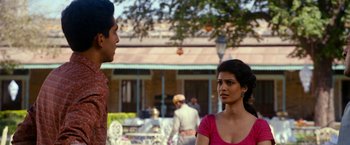 Movie still from “The Second Best Exotic Marigold Hotel” (2015), directed by John Madden – A man and a woman are standing in front of a building; Medium shot, Over the shoulder angle