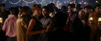 Movie still from “The Second Best Exotic Marigold Hotel” (2015), directed by John Madden – A group of people standing in a room with lights in the background; Medium shot, Over the shoulder angle