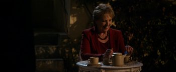 Movie still from “The Second Best Exotic Marigold Hotel” (2015), directed by John Madden – A woman sitting at a table with two cups of coffee; Medium shot, Over the shoulder angle