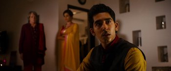 Movie still from “The Second Best Exotic Marigold Hotel” (2015), directed by John Madden – A man and a woman standing next to each other in a room; Medium shot, Over the shoulder angle