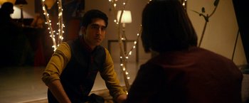 Movie still from “The Second Best Exotic Marigold Hotel” (2015), directed by John Madden – A man and a woman sitting in front of each other in front of lights; Medium shot, Over the shoulder angle