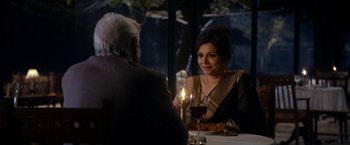 Movie still from “The Second Best Exotic Marigold Hotel” (2015), directed by John Madden – An older man and a woman sitting at a dinner table; Medium shot, Over the shoulder angle
