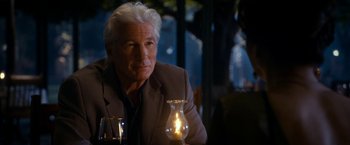 Movie still from “The Second Best Exotic Marigold Hotel” (2015), directed by John Madden – An older man sitting in front of a lit candle; Close Up shot, Over the shoulder angle