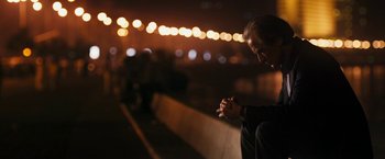 Movie still from “The Second Best Exotic Marigold Hotel” (2015), directed by John Madden – A man sitting on the side of a road at night; Medium shot, Low angle