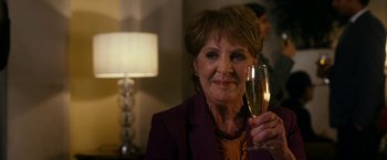 Movie still from “The Second Best Exotic Marigold Hotel” (2015), directed by John Madden – An older woman holding a glass of champagne; Close Up shot, Over the shoulder angle