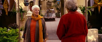 Movie still from “The Second Best Exotic Marigold Hotel” (2015), directed by John Madden – Two older women standing on the sidewalk talking; Medium shot, Over the shoulder angle