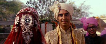 Movie still from “The Second Best Exotic Marigold Hotel” (2015), directed by John Madden – A man wearing a turban and a white turban is standing next to a woman; Close Up shot, Over the shoulder angle