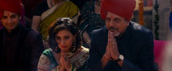 Movie still from “The Second Best Exotic Marigold Hotel” (2015), directed by John Madden – A man and a woman in traditional indian garb praying; Medium shot, High angle