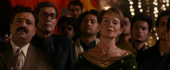 Movie still from “The Second Best Exotic Marigold Hotel” (2015), directed by John Madden – A group of men and women standing in a room; Medium shot, Over the shoulder angle