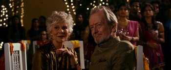 Movie still from “The Second Best Exotic Marigold Hotel” (2015), directed by John Madden – An older man standing next to an older woman; Close Up shot, Over the shoulder angle