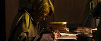 Movie still from “The Second Best Exotic Marigold Hotel” (2015), directed by John Madden – An older woman writing on a piece of paper; Close Up shot, Low angle