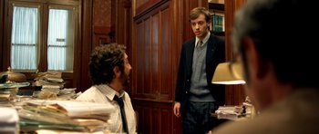 Movie still from “The Secret in Their Eyes” (2009), directed by Juan José Campanella – A man in a suit standing next to another man in a tie; Medium shot, Over the shoulder angle