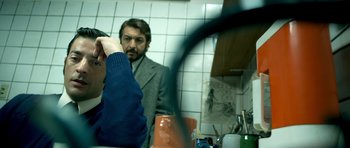 Movie still from “The Secret in Their Eyes” (2009), directed by Juan José Campanella – A man is looking in the mirror in a bathroom; Medium shot, Over the shoulder angle