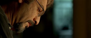 Movie still from “The Secret in Their Eyes” (2009), directed by Juan José Campanella – A person wearing glasses; Close Up shot, Low angle