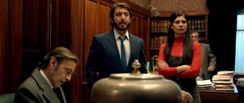 Movie still from “The Secret in Their Eyes” (2009), directed by Juan José Campanella – A man in a suit standing next to a woman; Medium shot, Low angle